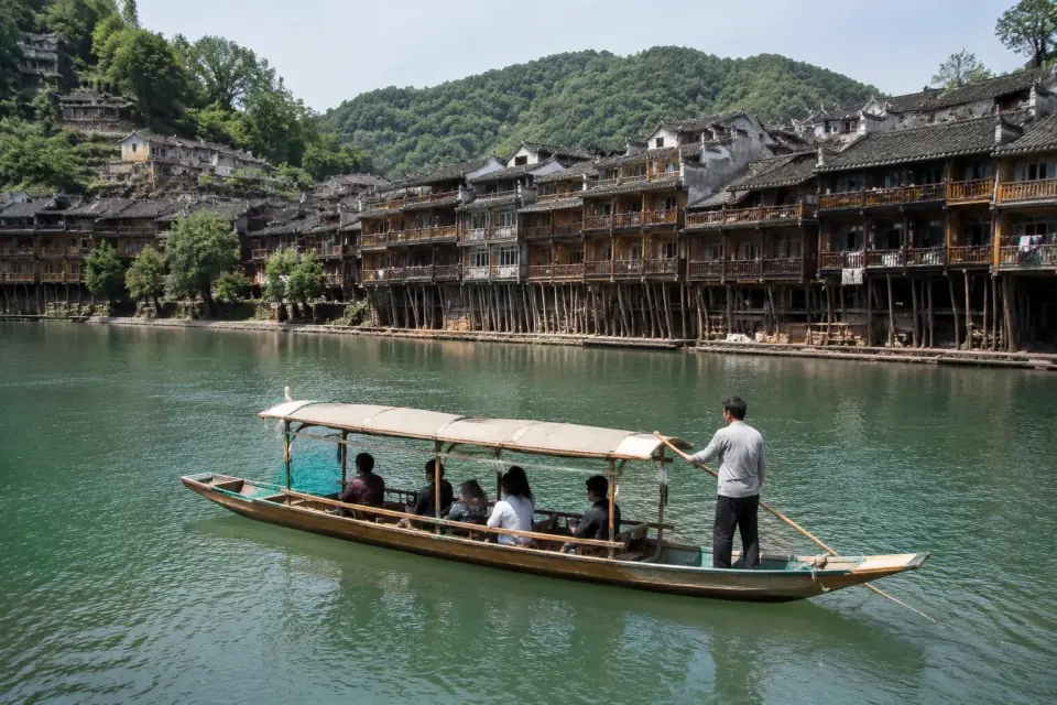 Barca tradicional navegando por el río Tuo en Fenghuang